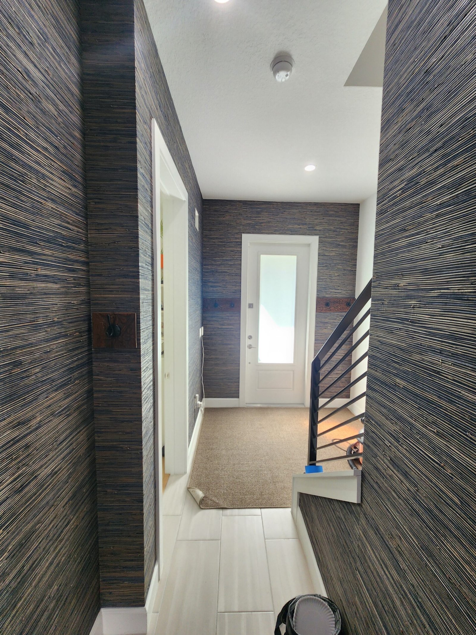 Professionally wallpapered interior entryway with detailed wallcovering